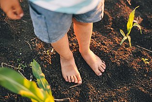 Person steht im Gartenbeet