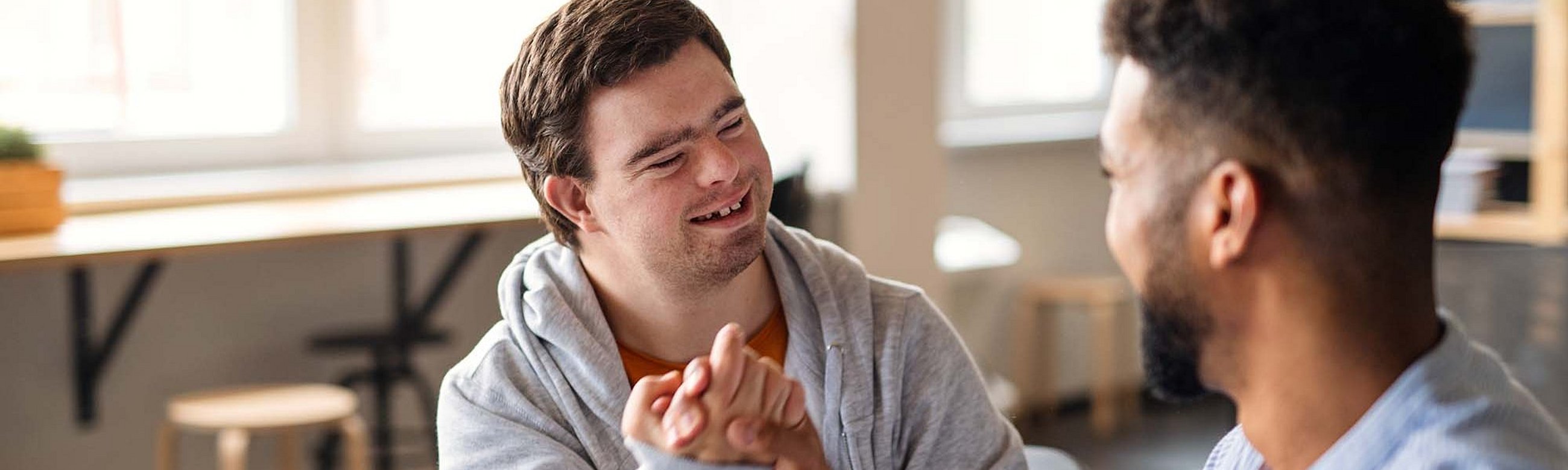 Zwei Männer, einer davon mit Down Syndrom, machen einen Bro-Handshake