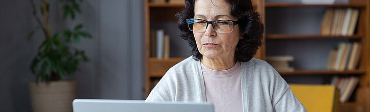 Frau guckt auf Laptop